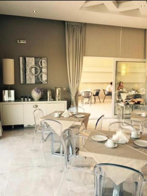 a dining room with tables and chairs in a room at Ammos Suites in Platy