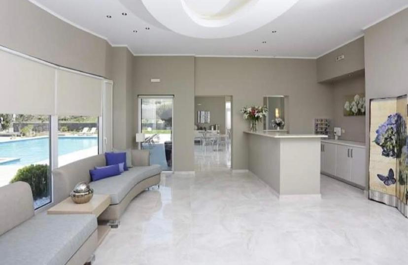 a large living room with a couch and a kitchen at Ammos Suites in Platy