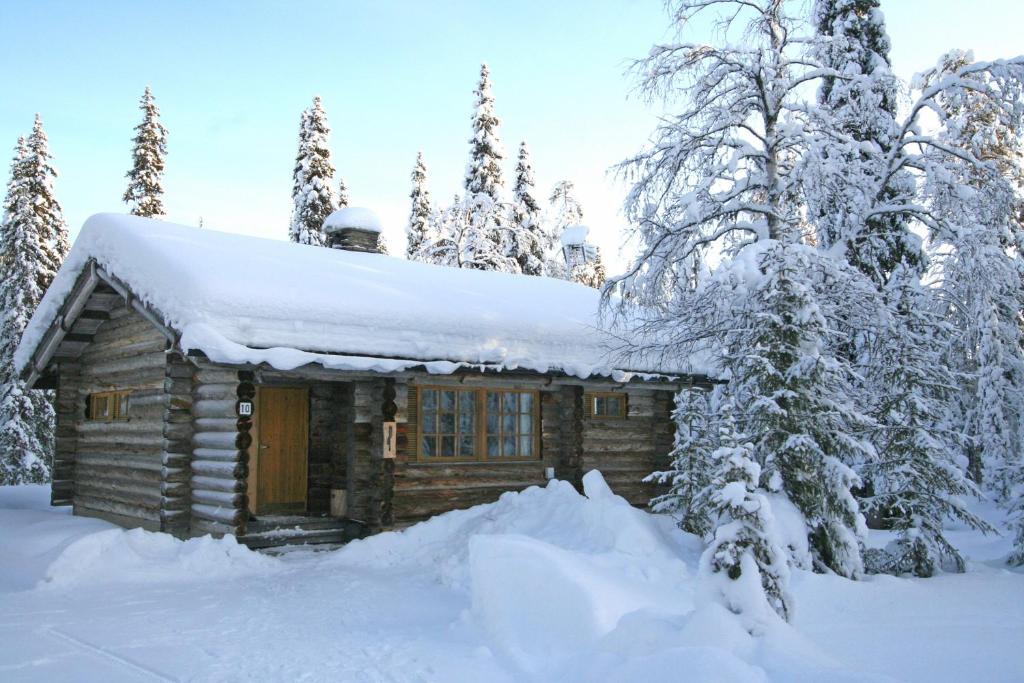 una baita di tronchi nella neve con alberi di Holiday Home Aurora Cabin a Luosto