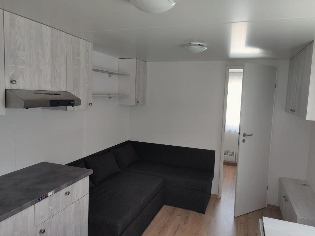 uma sala de estar com um sofá preto numa cozinha em Lux Camping Costinesti em Costinesti