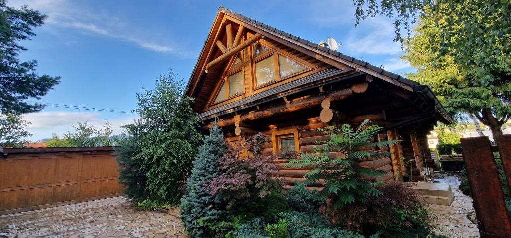 una cabaña de madera con una valla y una casa en Chata Zemra en Nitrianske Rudno
