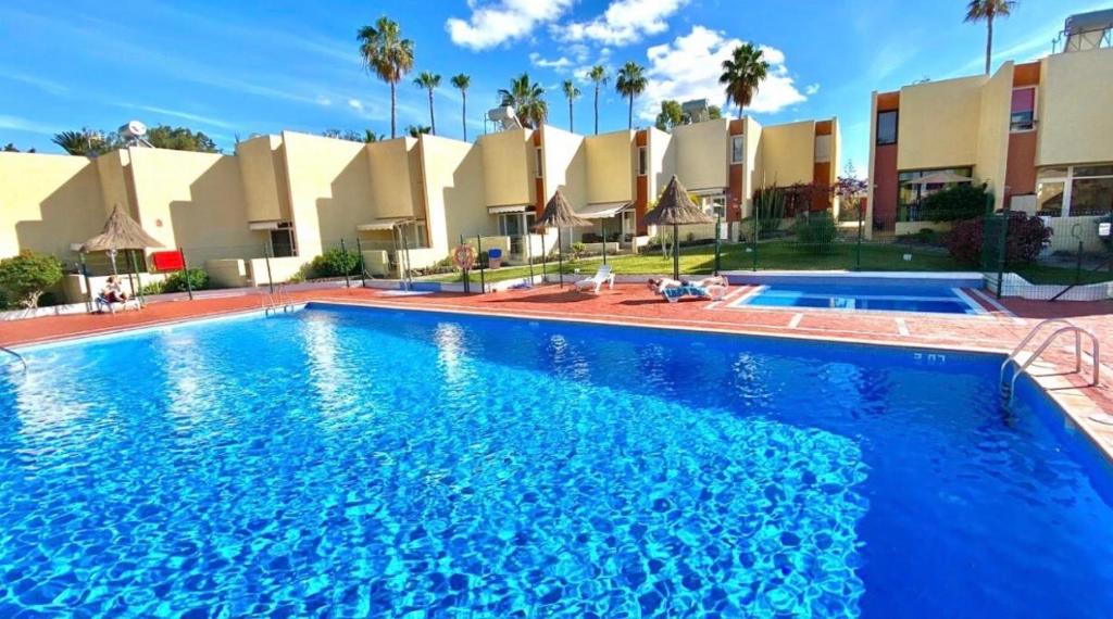 a large swimming pool in front of a building at El Cortijo Bungallows in Playa de las Americas