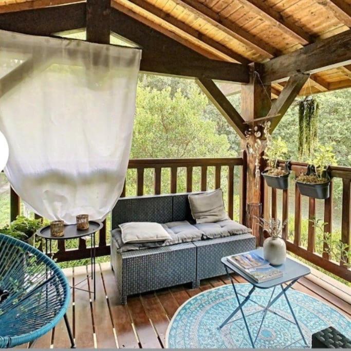 d'une terrasse en bois avec un canapé. dans l'établissement La maison près du Lac, à Aureilhan