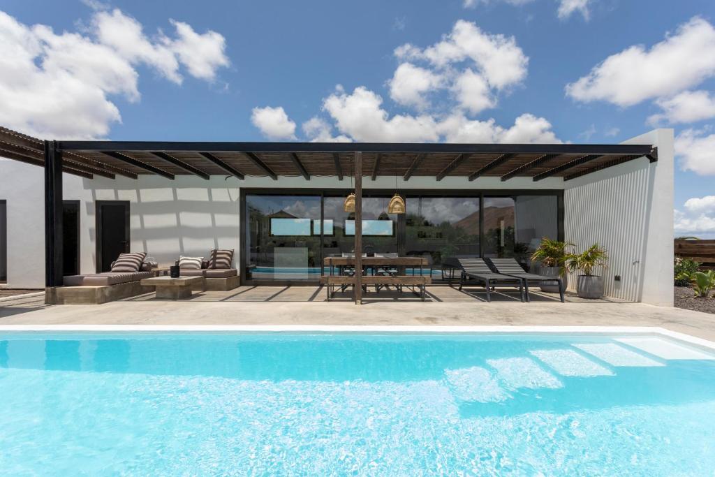 einen Pool vor einem Haus mit einer Terrasse in der Unterkunft Villa Borea - AlisiaFuerteventura in Villaverde