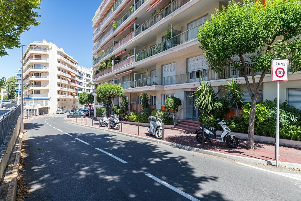 a street with three scooters parked in front of a building at St George in Antibes