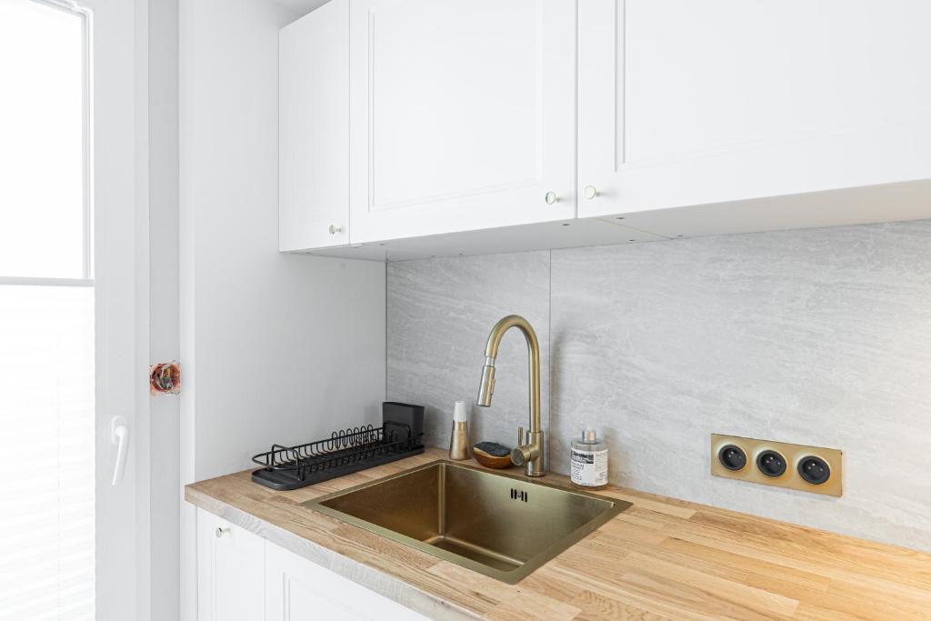 a kitchen with a stainless steel sink and white cabinets at St George in Antibes