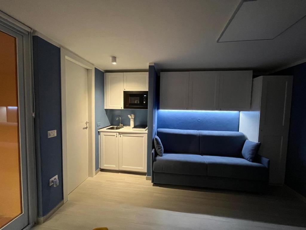 - un canapé bleu dans une chambre avec cuisine dans l'établissement Blue Portisco, à Marina di Portisco