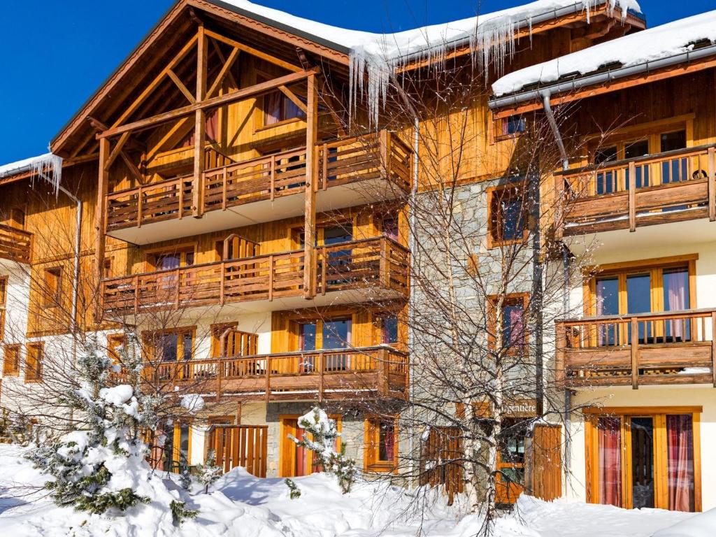 un grand bâtiment avec de la neige devant lui dans l'établissement Spacious apartment 500 m from the slopes of Les Sybelles, à La Toussuire