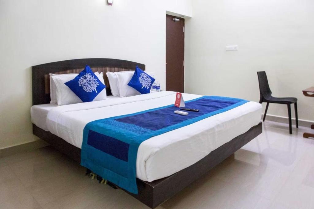 a bedroom with a large bed with blue and white pillows at AN STAYS Chennai Airport in Chennai