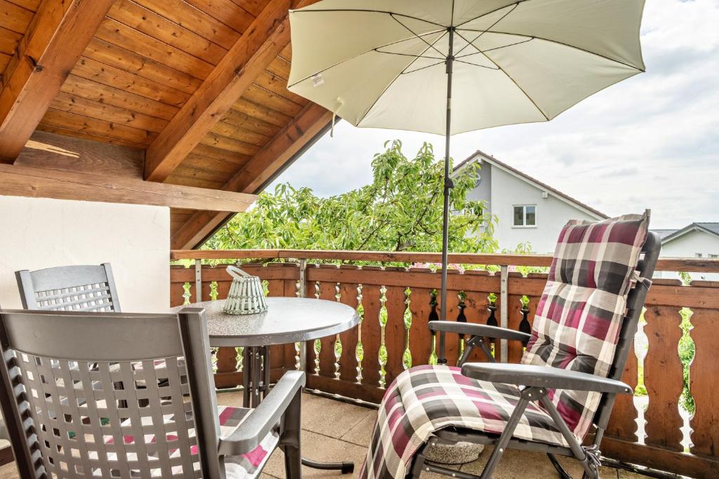 a patio with a table and chairs and an umbrella at Drei-mädelhaus Ambs Wohnung 1 in Ravensburg