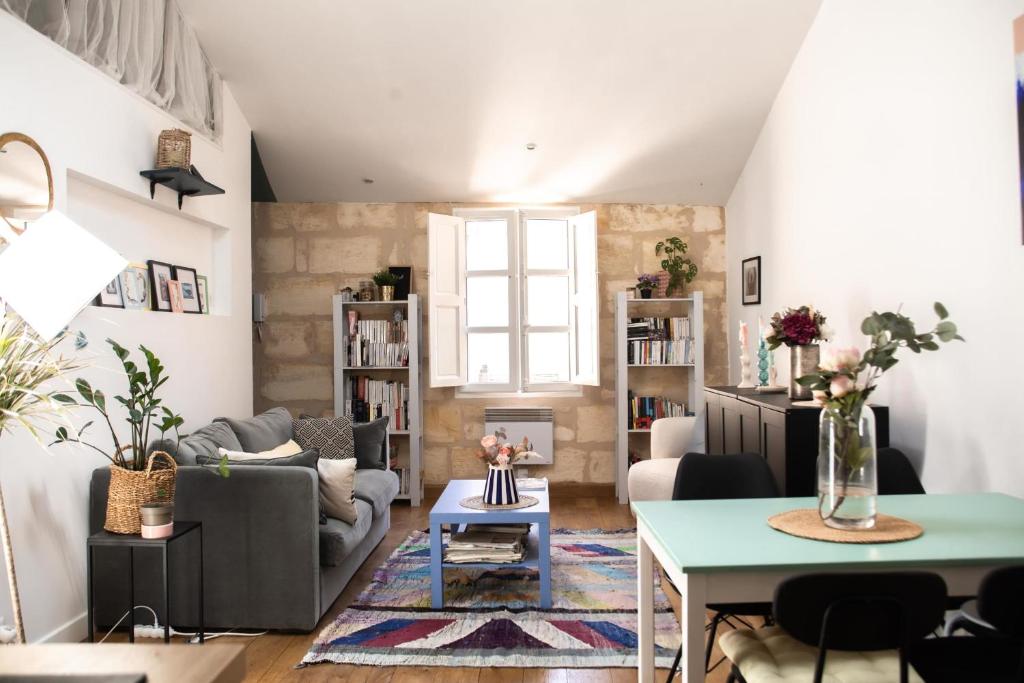 een woonkamer met een bank en een tafel bij Rare gem 2 steps from the heart of Bordeaux in Bordeaux