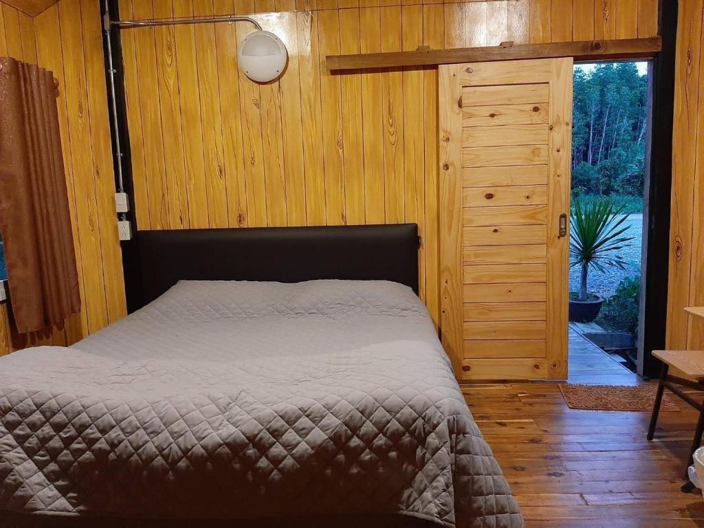 um quarto com uma cama e uma parede de madeira em หวานใจ โฮมสเตย์ (Whanjai Homestay) em Laem Ngop