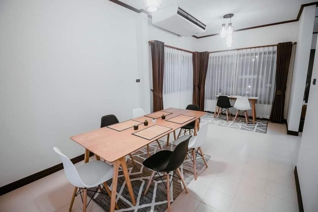 una sala de conferencias con mesa de madera y sillas en BannPordee en Nakhon Si Thammarat