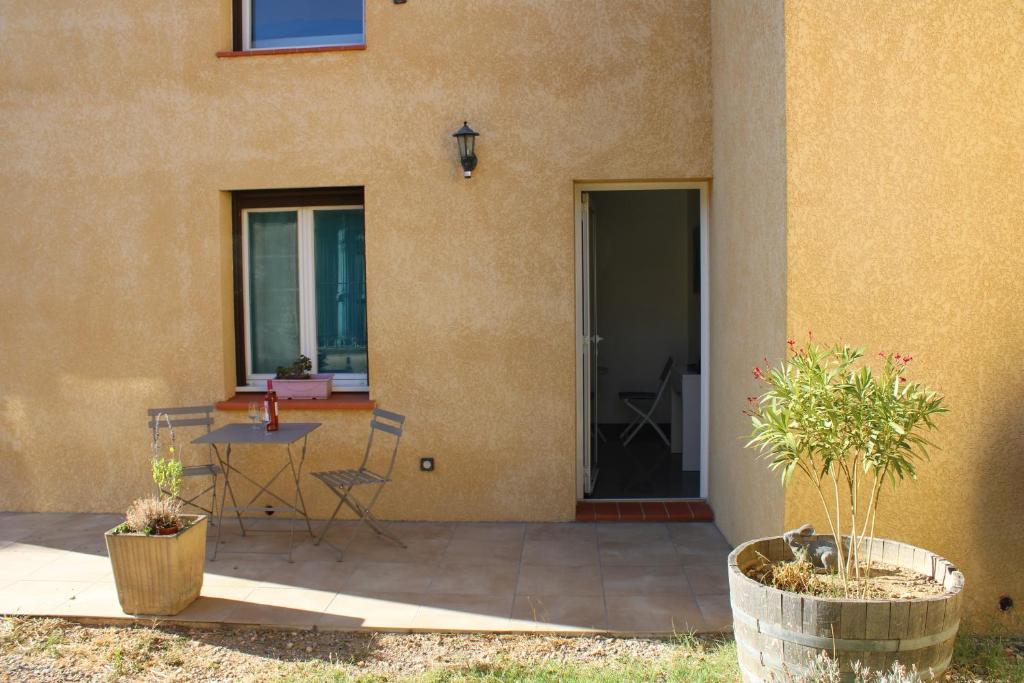 a patio with a table and chairs next to a building at Chambre d'hôtes les trois chemins in Cucugnan