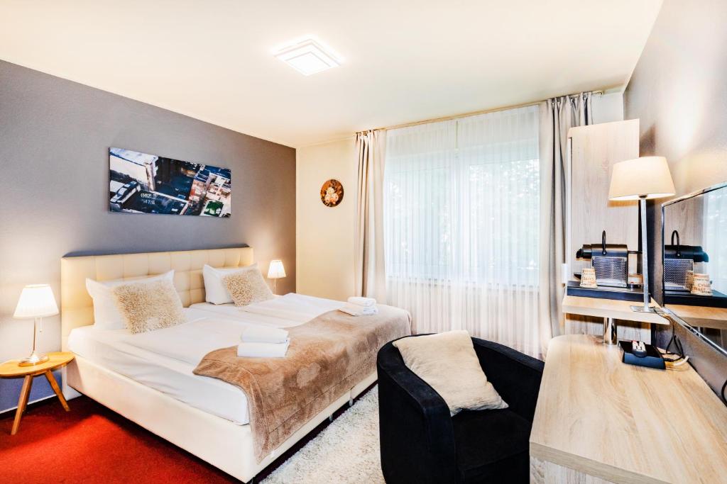 a bedroom with a bed and a large window at Hotel Fürst Garden in Dortmund