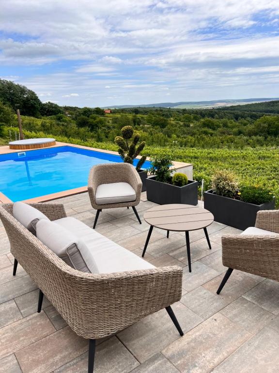 een patio met rieten meubels en een zwembad bij Edelin Wine House in Edelény