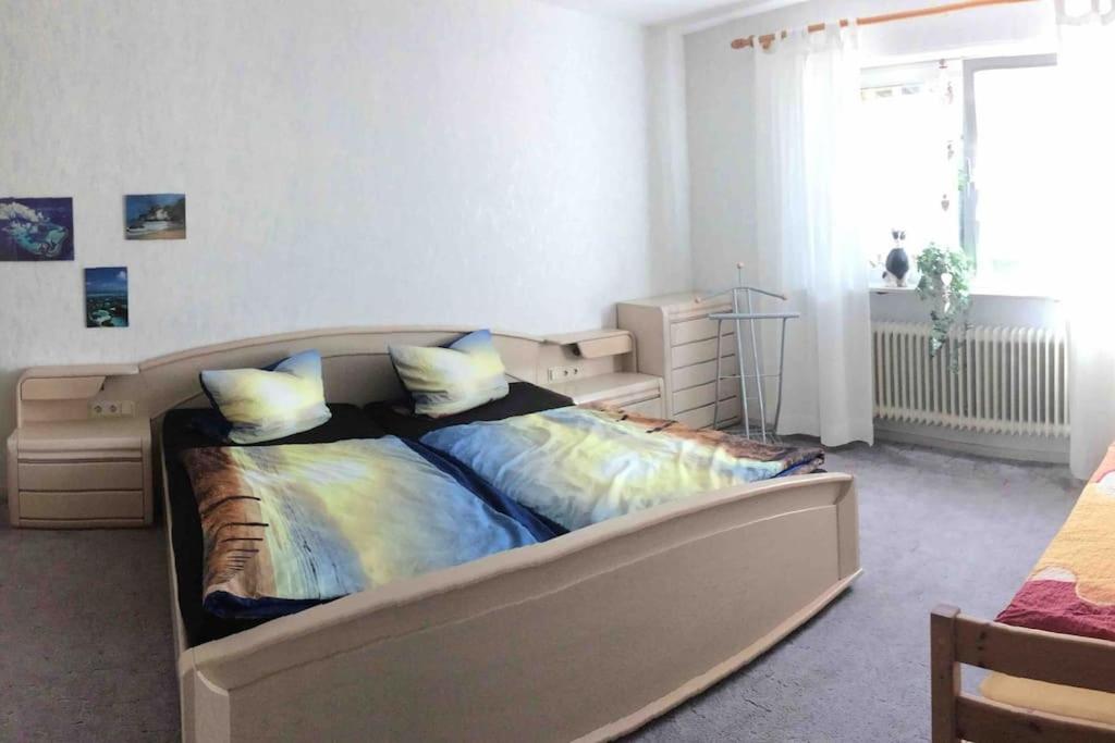 - une chambre avec un lit dans une pièce dotée d'une fenêtre dans l'établissement Ferienwohnung Forstwiese, à Großrosseln