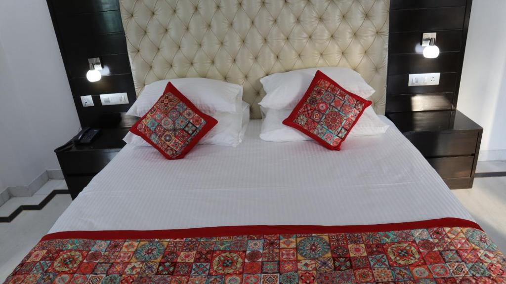 1 dormitorio con 1 cama con 2 almohadas rojas en VENUS.HOTEL, en Mohali