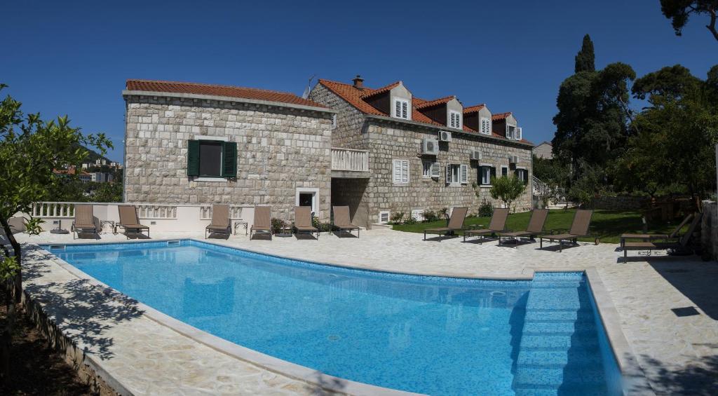a large swimming pool in front of a house at Bokun Guesthouse in Dubrovnik