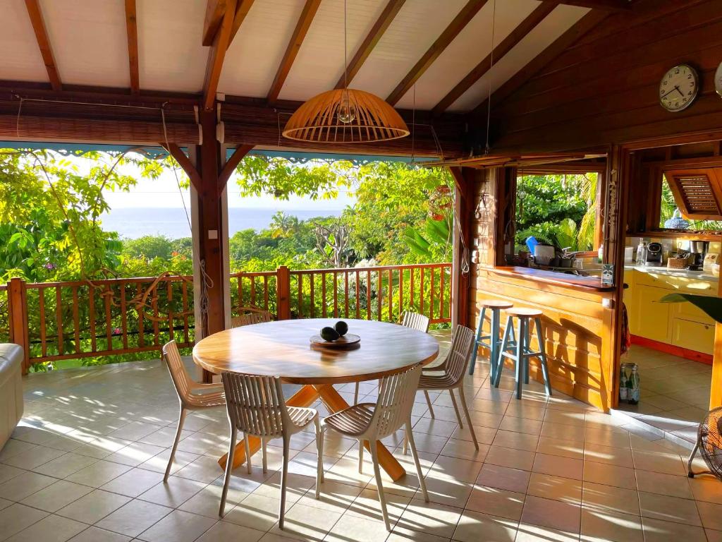 - une terrasse couverte avec une table et des chaises sur un balcon dans l'établissement Villa Nature caraïbe lodge, vue mer, piscine privée, à Deshaies