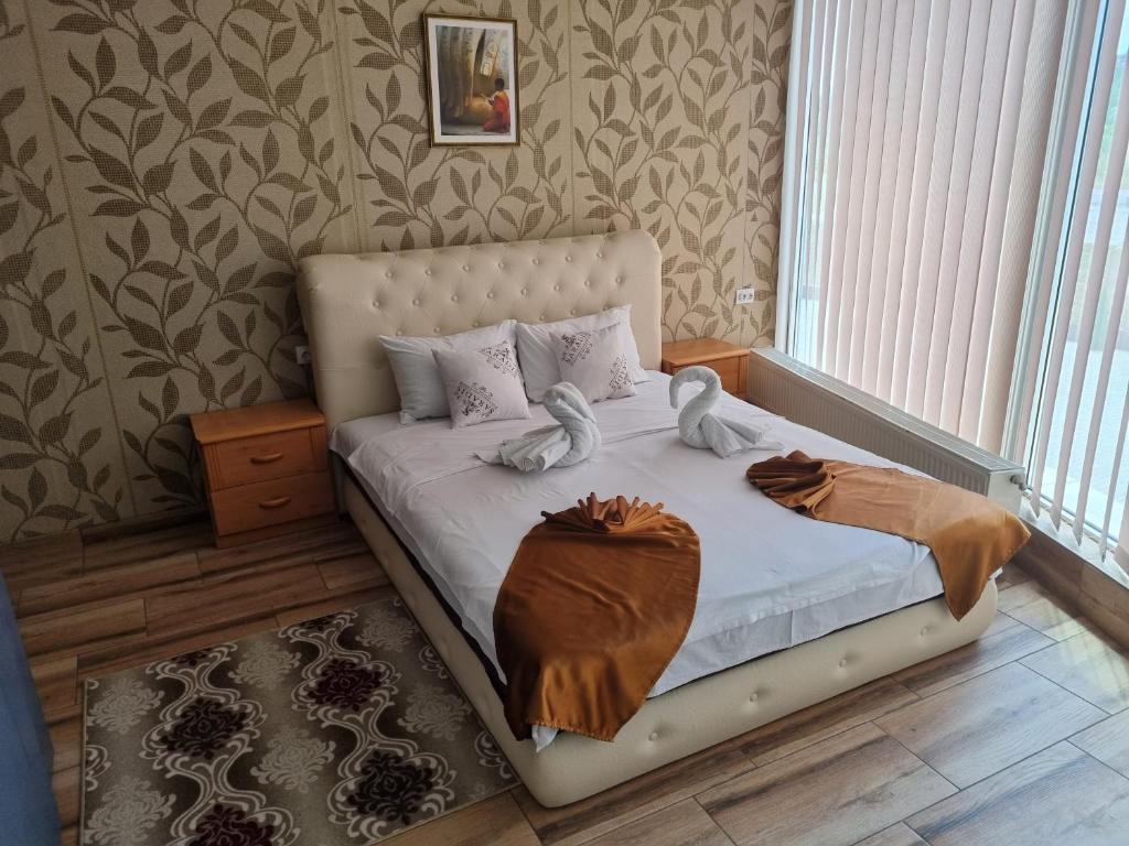 a bedroom with a bed with two towels on it at Hotel Saradis in Kruševac