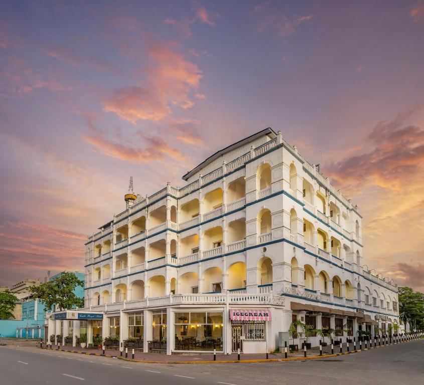 un grand bâtiment blanc situé sur le côté d'une rue dans l'établissement Sentrim Castle Royal Hotel, à Mombasa