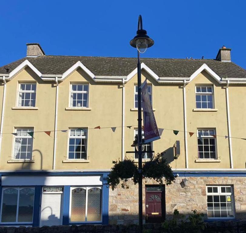 un edificio con una luz de la calle delante de él en Paddy Mac's Self Catering Holiday Bar, en Drumshanbo