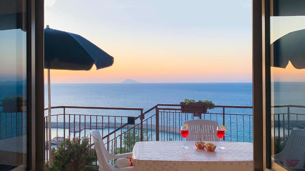 un tavolo su un balcone con vista sull'oceano di Perla d'Orlando a Capo dʼOrlando