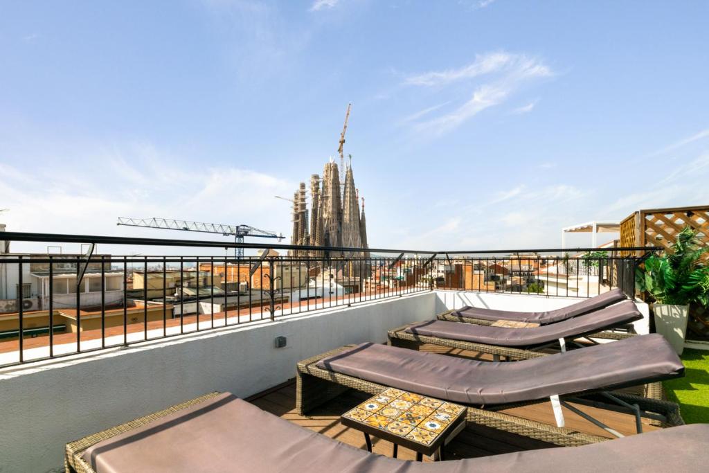 balcón con tumbonas y vistas a la ciudad en Suite Home Sagrada Familia, en Barcelona