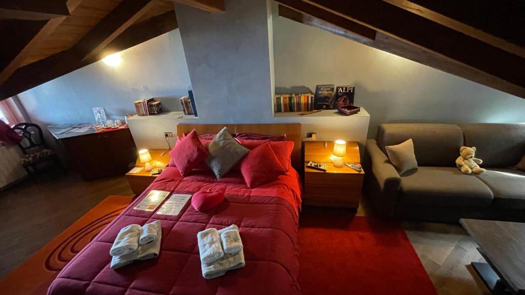 a bedroom with a large red bed and a couch at Alba sul lago B&B in Stresa