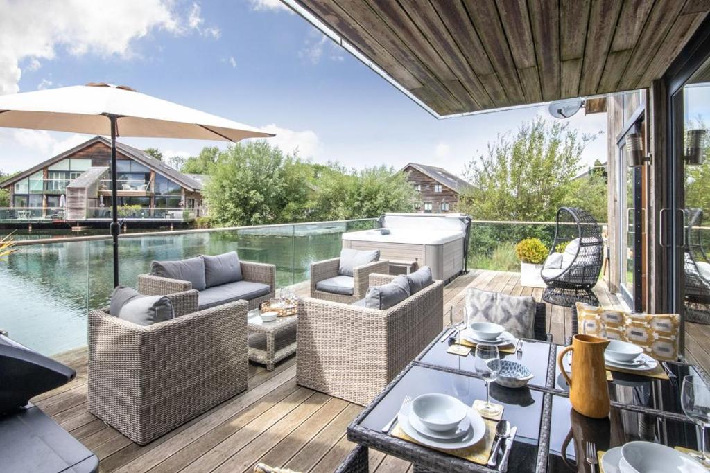 a patio with a table and chairs and a pool at Waters Edge 15, Kingsholm P in South Cerney