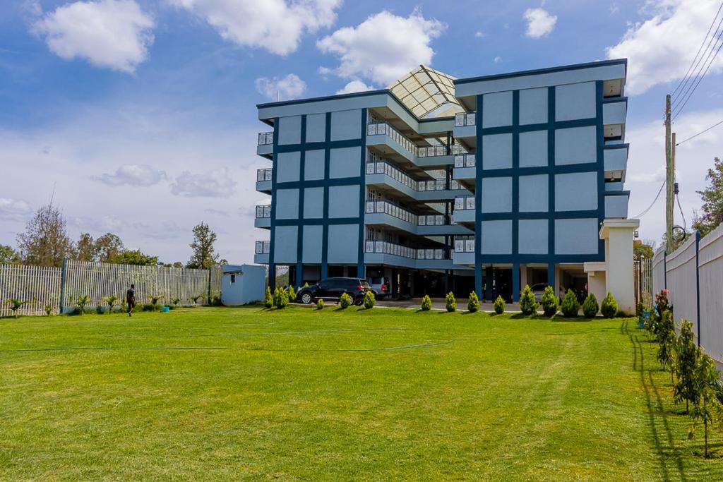 a large blue building with a large grass yard at Ebony Batian Nanyuki 1bedroom in Nanyuki