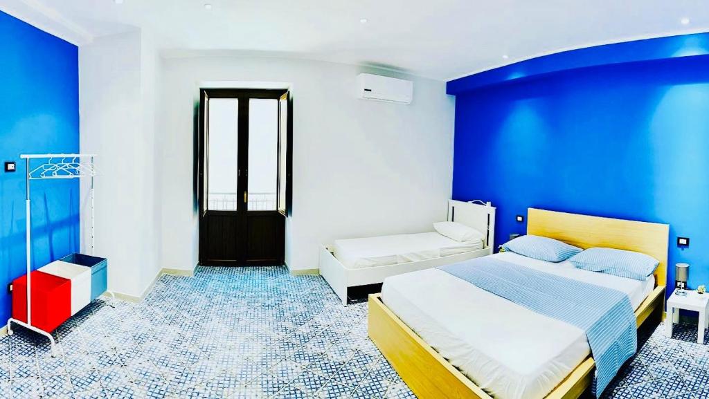 a blue and white bedroom with a bed and a couch at Corleone Home in Corleone