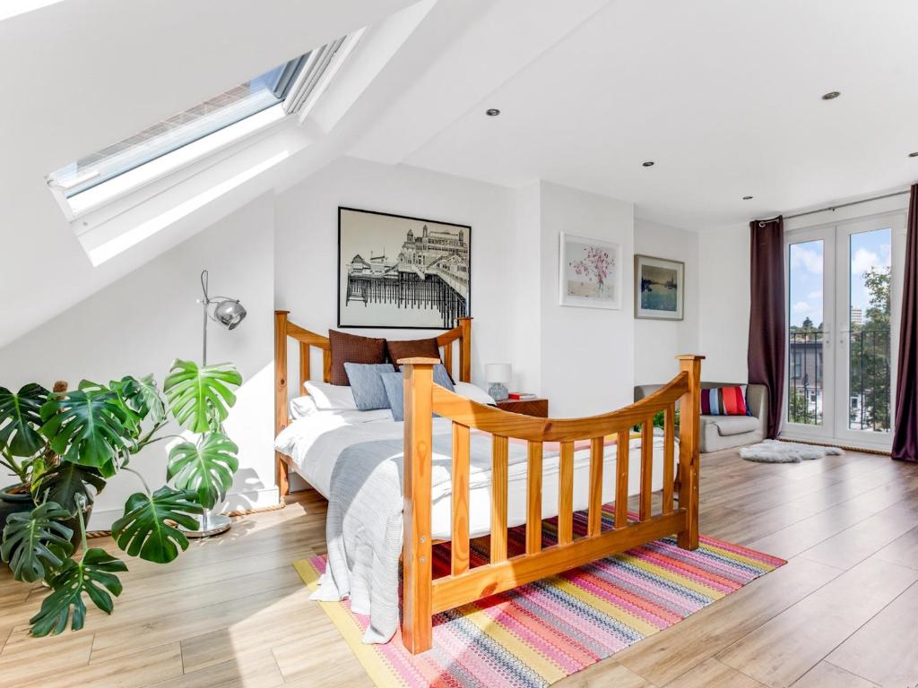 een slaapkamer met een bed en een groot raam bij Pass the Keys Stunning 3BR House with Garden Oasis in Londen