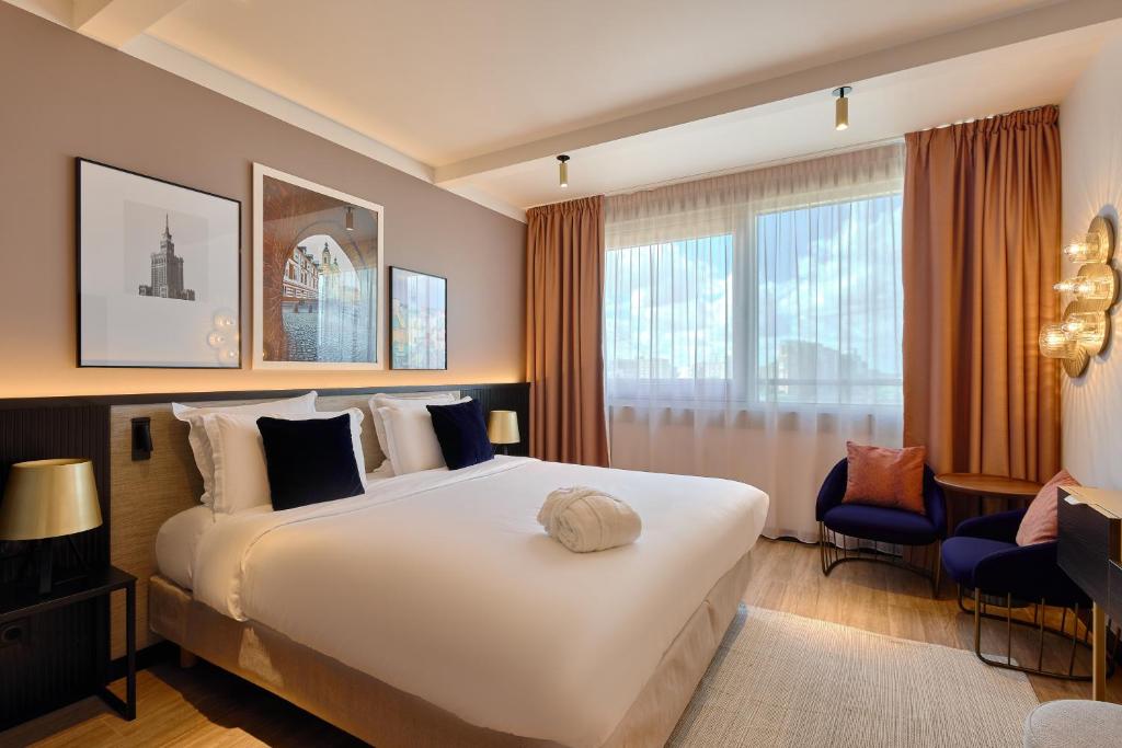 una camera d'albergo con un grande letto e una finestra di Golden Tulip Warsaw Centre a Varsavia
