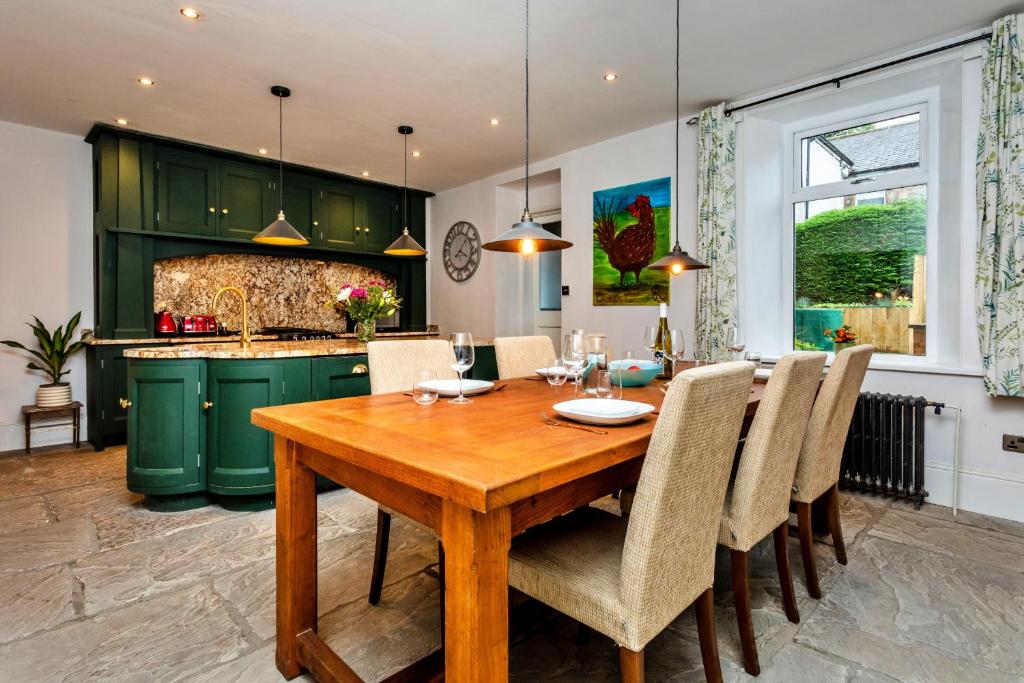 a kitchen and dining room with a wooden table and chairs at Finest Retreats - Upper Howick House in Alnwick