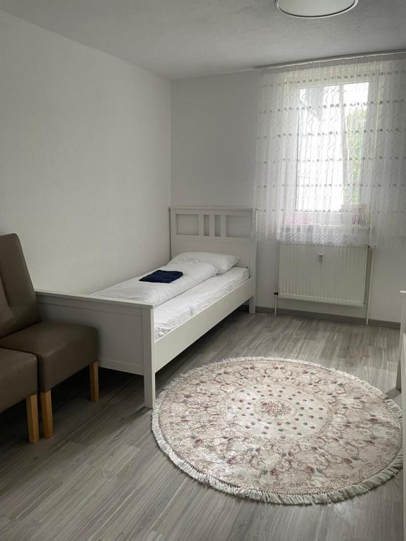 a bedroom with a bed and a chair and a rug at Ferienwohnung Monteurwohnung Kassel zentral ll in Kassel