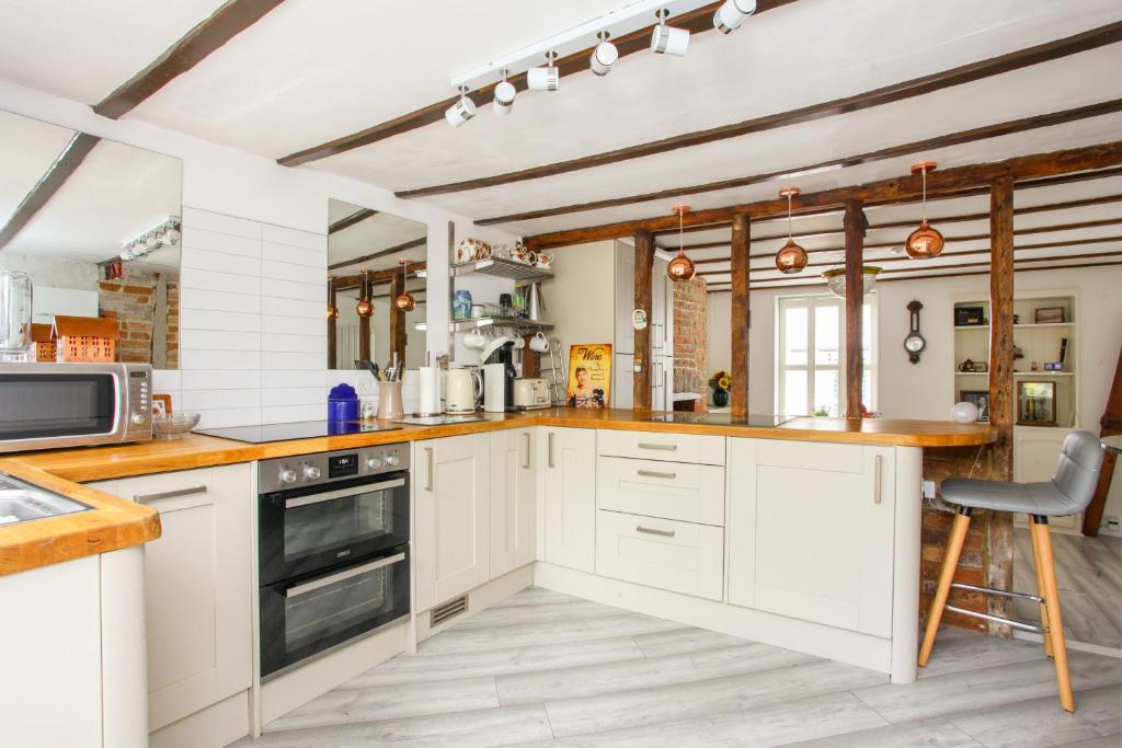 eine Küche mit weißen Schränken und einer Arbeitsplatte in der Unterkunft Newgate House, Sandwich in Sandwich