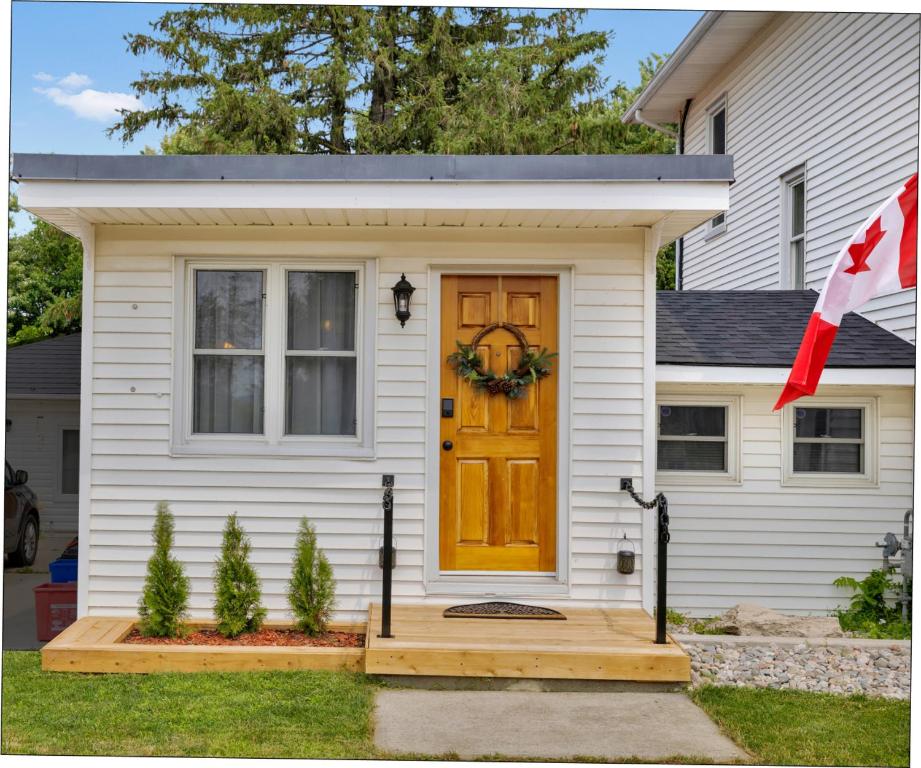 une maison avec une porte jaune et une terrasse couverte dans l'établissement Cozy Kingsville Country Home Guest House, à Kingsville