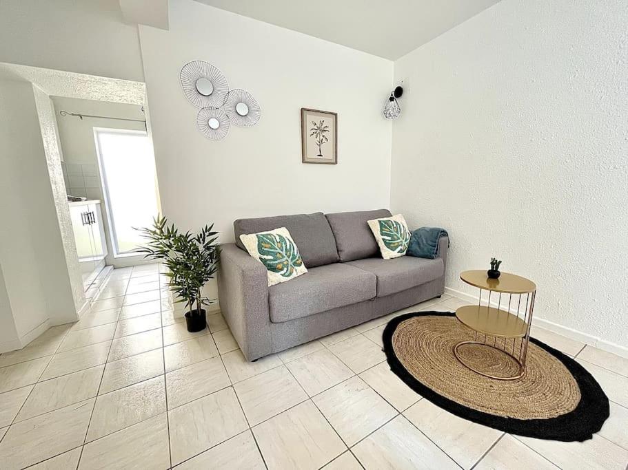 un salon avec un canapé et une table dans l'établissement La Topaze Bleue - Romans, à Romans-sur-Isère