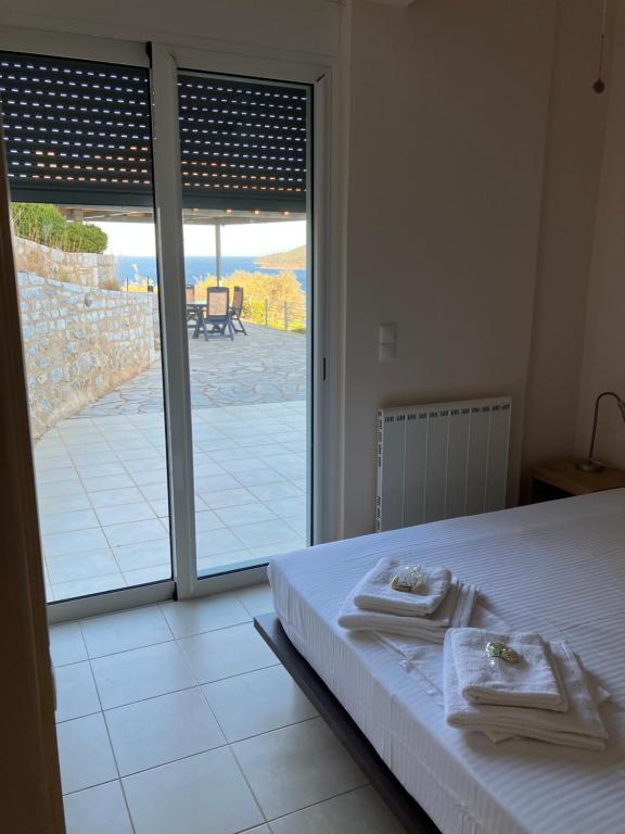 a bedroom with a bed and a view of a patio at Ageranos seaview house in Kamáres