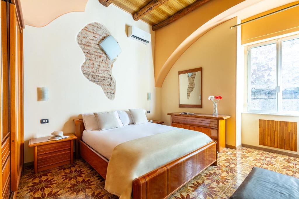 een slaapkamer met een groot bed en een raam bij Amphitheater Apartment by Wonderful Italy in Napels