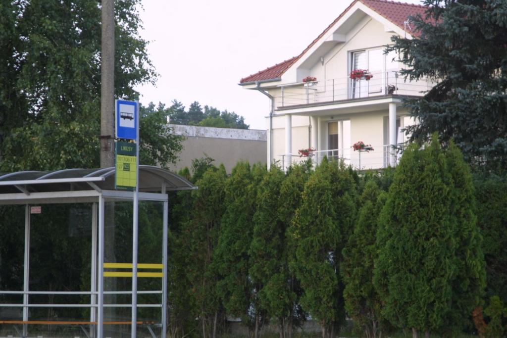 una casa con un cartel frente a un edificio en Hotelik Likusy - przy plaży nad jeziorem Ukiel i z bezpłatnym prywatnym parkingiem, en Olsztyn
