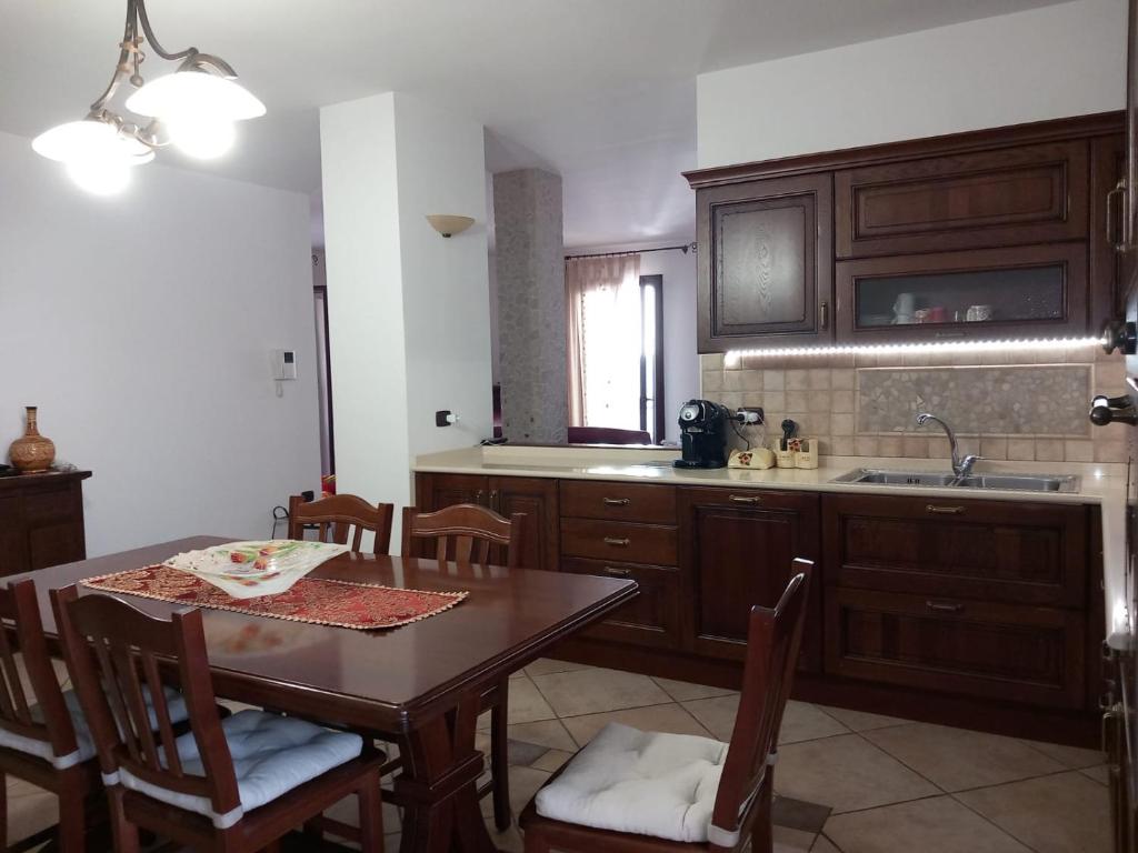 a kitchen with a table and chairs and a sink at Casa di Ale in Trepuzzi