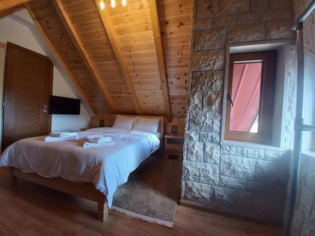 a bedroom with a bed and a stone wall at View of the Durmitor in Žabljak
