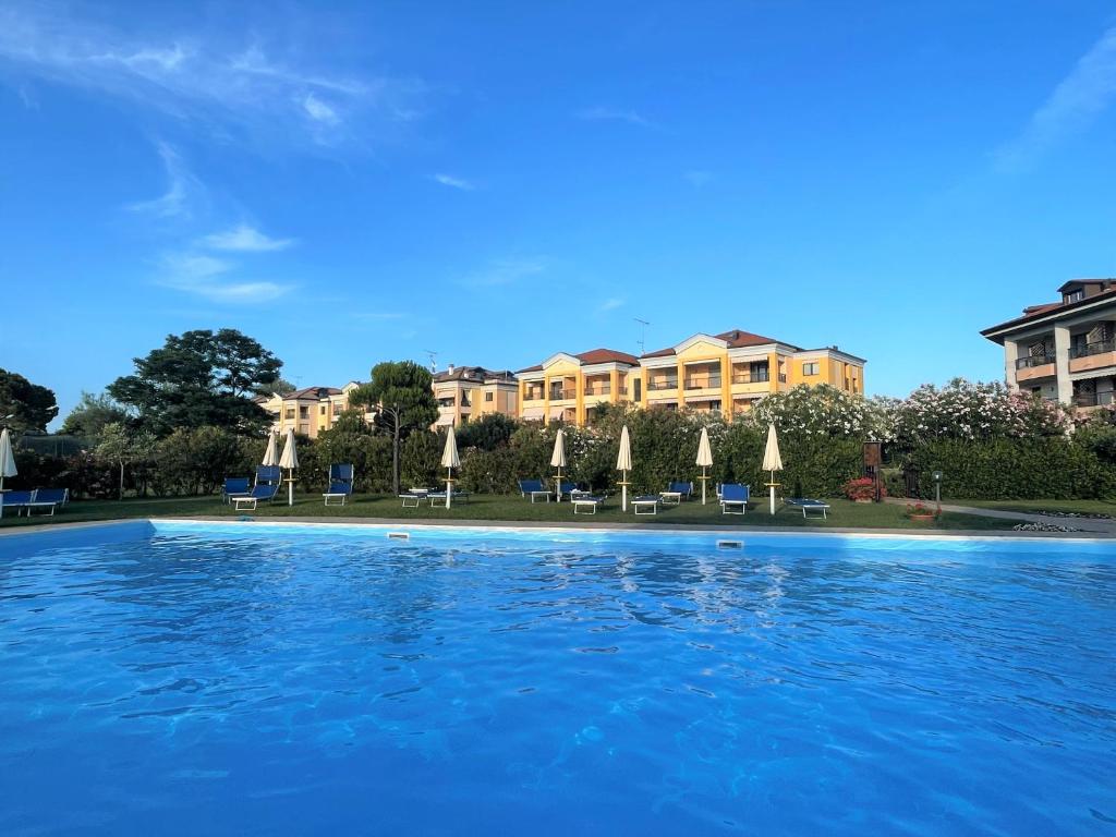 een groot zwembad met stoelen en parasols bij Calilla Home-appartamento Scirocco in Grado
