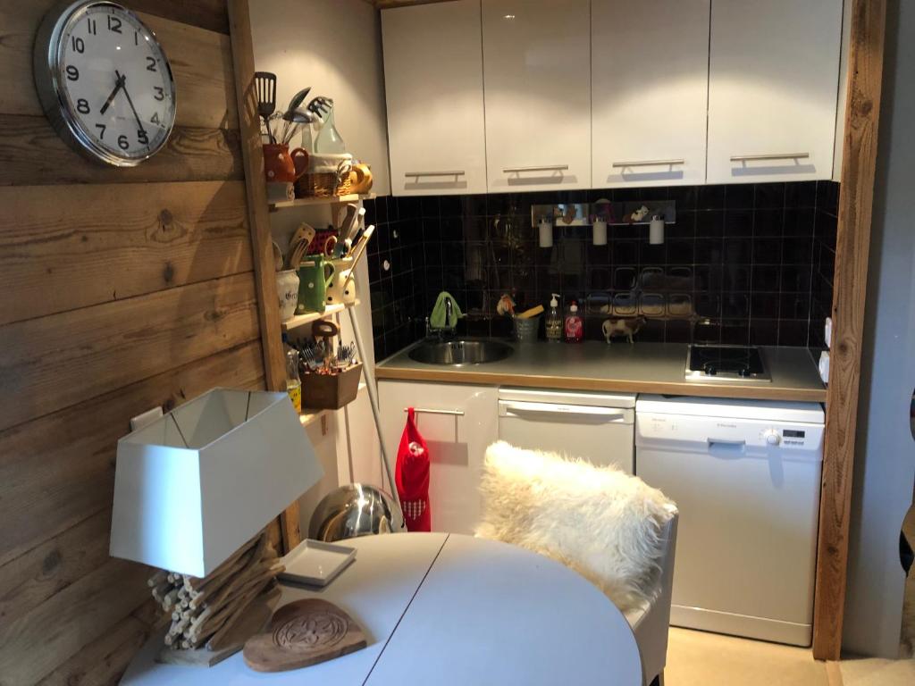 a kitchen with a counter and a clock on the wall at Tignes : cocon luxueux au pied des pistes in Tignes