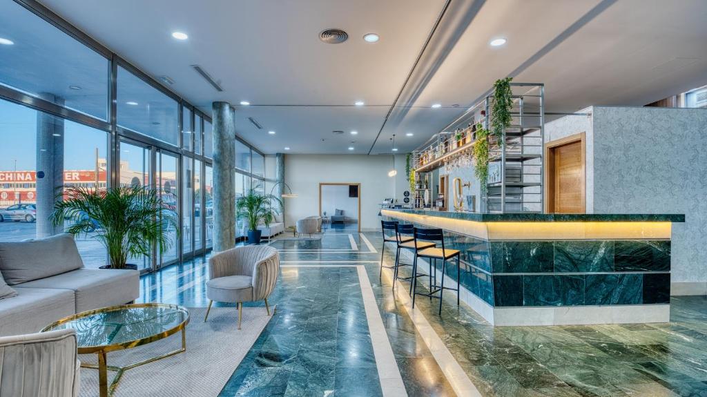 vestíbulo con bar, sillas y ventanas en Checkin Madrid Móstoles, en Móstoles