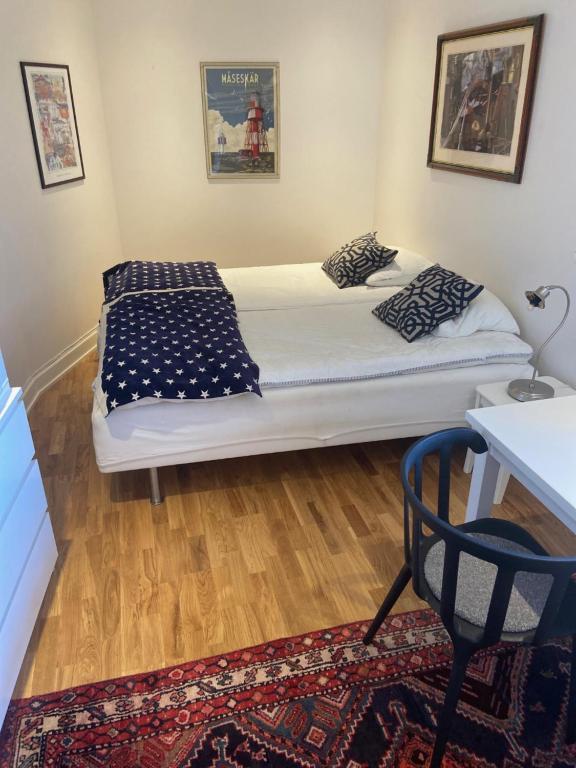 1 dormitorio con cama, mesa y alfombra en Logi & Bastu, en Käringön