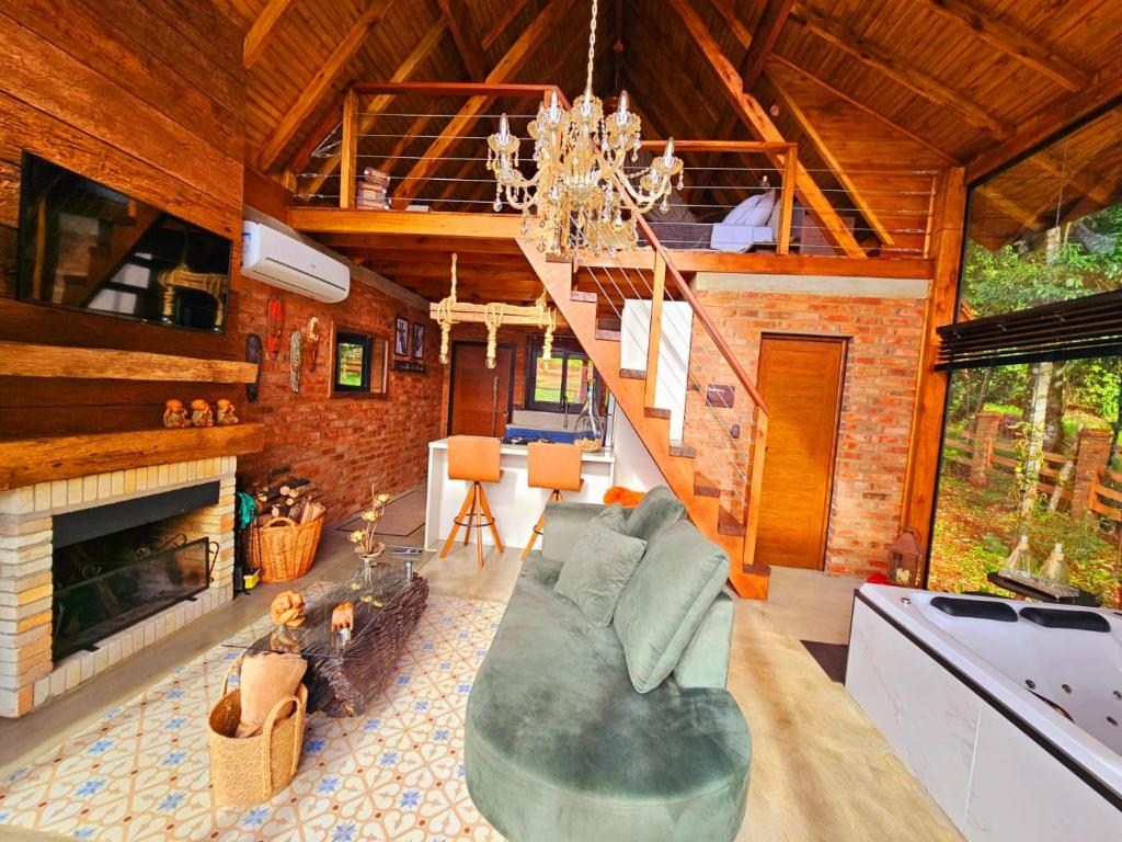 ein Wohnzimmer mit einem Sofa und einem Kamin in der Unterkunft Cabanas Bougainville Hospedagem sofisticada em nova Petrópolis in Nova Petrópolis